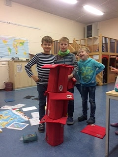 Auf dem Bild sind Schüler zu sehen, die den schiefen Turm von Pisa nachgebaut haben.
