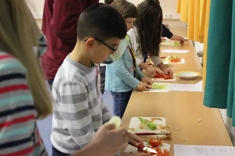 Auf dem Bild sind Sch&uuml;ler und Sch&uuml;lerinnen der Schule St. Magnus zu sehen, die eine T&uuml;rkische Pizza backen.
