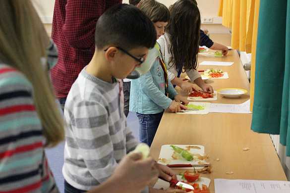 Auf dem Bild sind Schüler und Schülerinnen der Schule St. Magnus zu sehen, die eine Türkische Pizza backen.